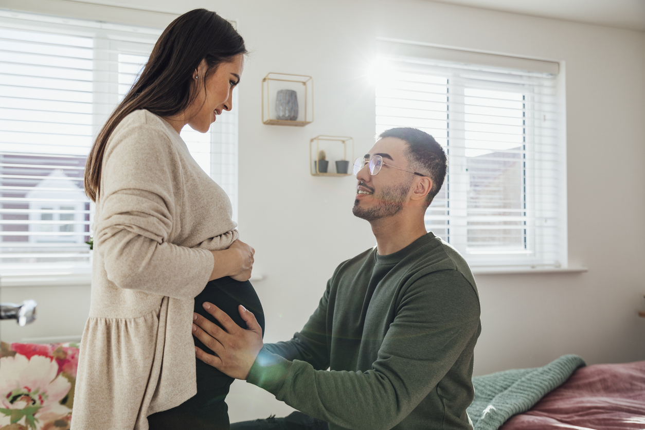Side view of a man holding his wife's pregnant stomach