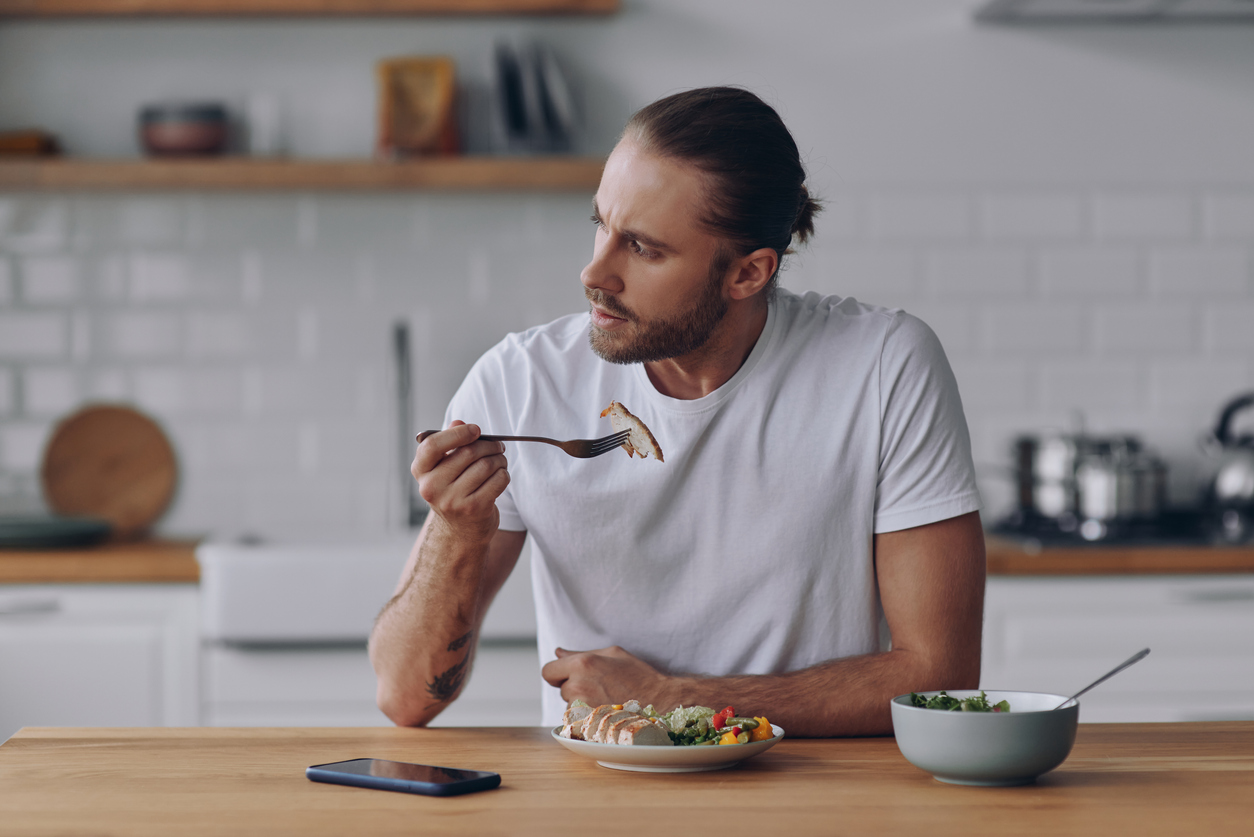 Man contemplating what he's eating and whether he should consider fasting for it's health benefits